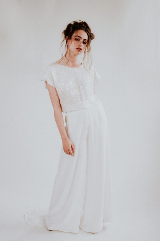 a modern and cute bridal look with a white sequin crop top with cap sleeves and white plain wideleg pants is chic