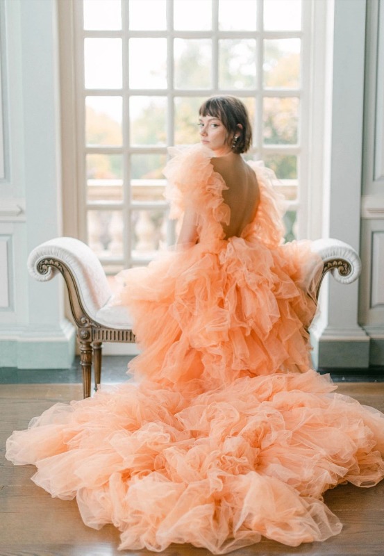 an orange A line tulle ruffle wedding dress with an open back will make a statement both with its color and its design