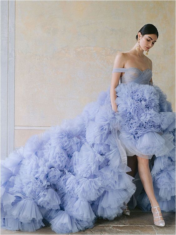 a jaw dropping off the shoulder blue wedding dress with a draped bodice and a ruffle tier skirt with a long train