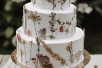 35 a subtle white buttercream wedding cake with pressed dried flowers and herbs is a lovely idea for a boho wedding