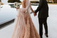 36 a jaw-dropping peachy pink A-line wedding dress with a ruffle skirt and a neutral veil for a statement bridal look