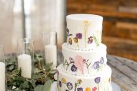 36 a subtle white buttercream wedding cake with pressed flowers and leaves of various colors is a lovely idea for spring