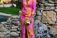 36 a super bold garden wedding guest look with a watercolor midi dress in orange, pink and yellow, orange shoes and a gold mini clutch
