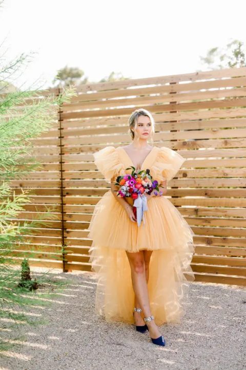 a jaw-dropping yellow tulle high low ruffle wedding dress and navy shoes with floral detailing