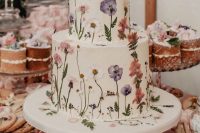 38 a very delicate white buttercream wedding cake with pressed white and pastel flowers and leaves is a great idea for spring