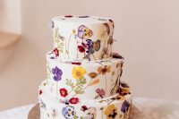 40 a white buttercream wedding cake with colorful pressed flowers and leaves is a cool idea for a bright boho wedding in summer