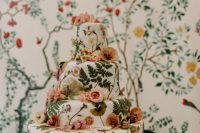 44 a white buttercream wedding cake with pressed dried blooms and leaves and some pastel flowers on top for a garden wedding