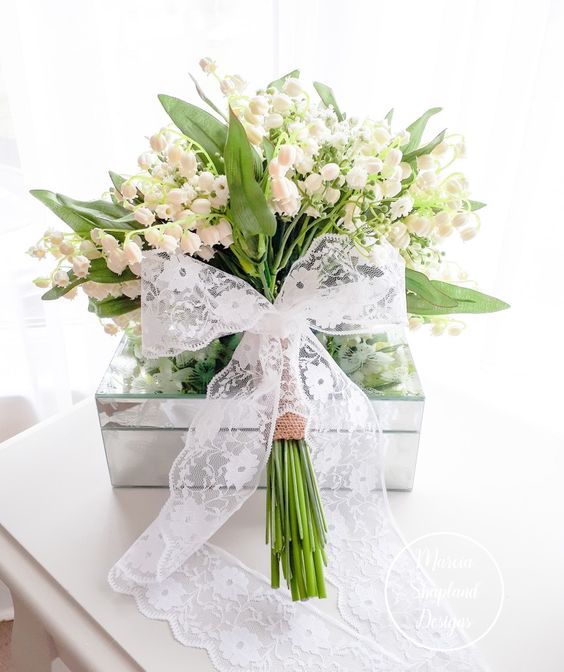 a pretty lily of the valley bouquet finished of beautifully with hessian and a lace bow for a vintage spring bride