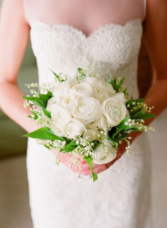 a refined spring wedding bouquet of lily of the valley, white ranunculus and greenery is a very chic solution