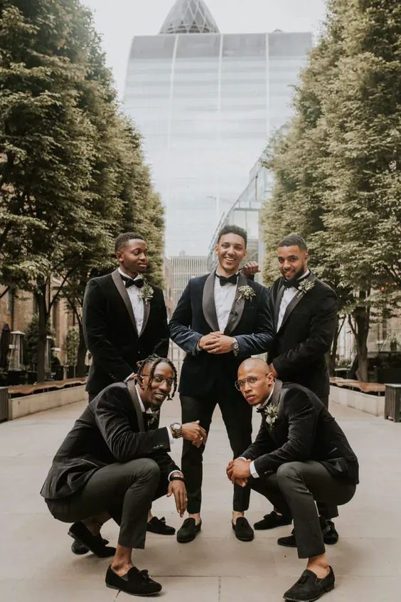 elegant black tuxedos with velvet dinner jackets and velvet loafers, white shirts and simple black trousers are great for a black tie wedding