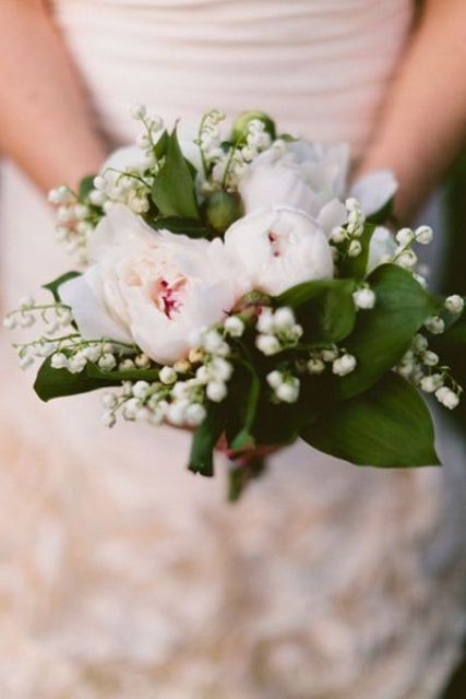 a spring wedding bouquet of blush peonies and foliage plus lily of the valley is a very catchy and chic idea for a bride