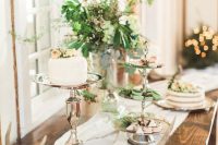 20 a chalet wedding cake table with a textural greenery and berry arrangement, antlers, gorgeous cakes and desserts on a tiered stand