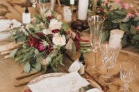 23 a gorgeous chalet wedding tablescape with an uncovered table, wood slice placemats, pink, burgundy blooms and greenery and coral napkins