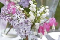 24 a beautiful and relaxed wedding centerpiece of a clear vase with lilac, white and pink blooms is a lovely idea for a spring wedding