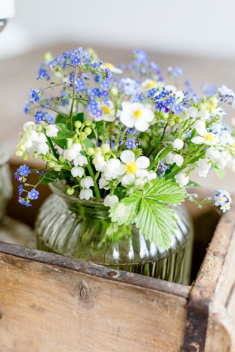 a beautiful rustic wedding centerpiece of lily of the valley, some white and blue wildflowers is amazing for a relaxed boho wedding