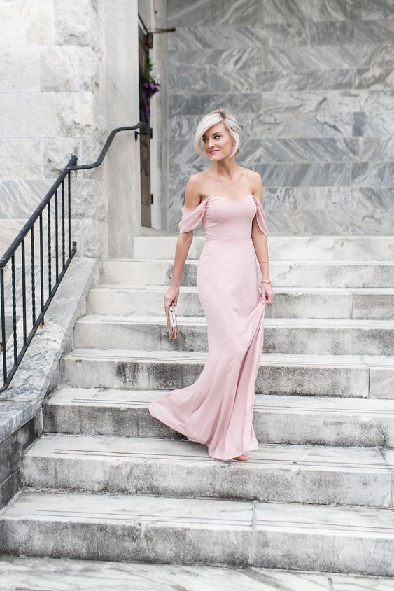 a delicate blush off the shoulder maxi dress and a neutral printed clutch for a very girlish look at the wedding