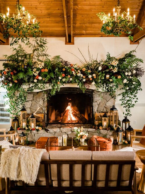a lovely chalet lounge with a fireplace, lots of blooms and greenery, candle lanterns and comfy furniture is ultimate