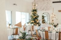 26 a lovely chalet wedding reception table with red and burgundy blooms, greenery, evergreens, pinecones and wood slices plus a Christmas tree