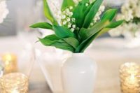 27 a delicate and stylish wedding centerpiece of a white vase and lily of the valley is a good idea for a spring wedding and you can DIY
