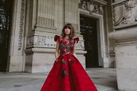 27 a fantastic red A-line dress with ruffle sleeves, a high neckline, a floral embellished bodice, a printed skirt, red shoes with pompoms