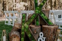 27 a pretty chalet wedding decoration of tree stumps and moss monograms, faceted candle lanterns is amazing for a forest wedding, too