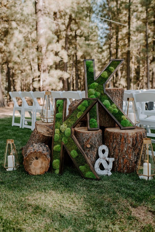 a pretty chalet wedding decoration of tree stumps and moss monograms, faceted candle lanterns is amazing for a forest wedding, too