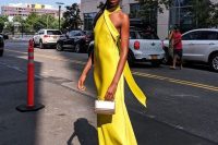 28 a fantastic sunny yellow maxi dress with a criss cross neckline, an open back, silver shoes and a mother of pearl mini bag