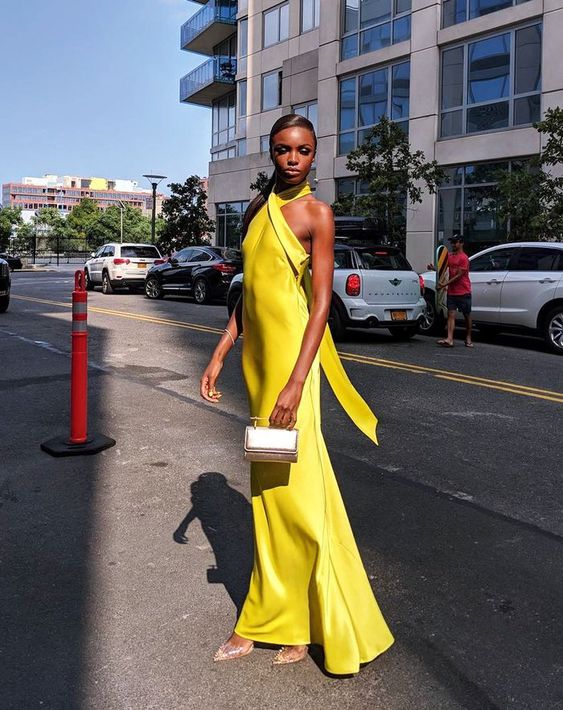 a fantastic sunny yellow maxi dress with a criss cross neckline, an open back, silver shoes and a mother of pearl mini bag