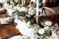 29 a rustic chalet wedding tablescape with neutral linens, lush white florals, tall and thin candles, white porcelain and gold cutlery