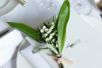 35 a white wedding tablescape with elegant porcelain and cutlery, with a lily of the valley card and a menu is very chic