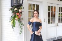 37 a navy off the shoulder A-line high low maxi dress, nude shoes and a blush clutch plus statement earrings for an elegant wedding
