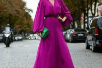 38 a purple high low maxi dress with puff sleeves and a deep neckline, a belt, an emerald clutch is amazing