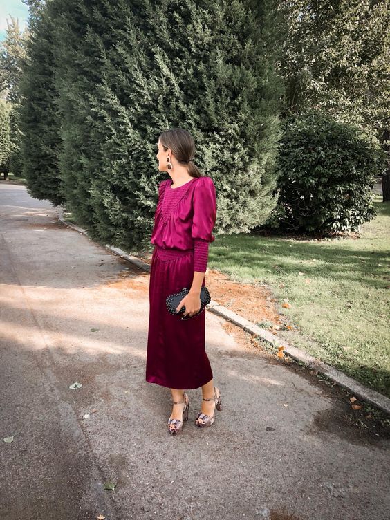 a purple midi dress with ribbed touches, accented shoulders, metallic shoes and an embellished black clutch