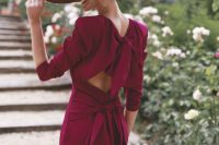 41 a refined and beautiful fuchsia fitting midi dress with short sleeves, accented shoulders, a cutout back with a sash and a wide brim hat
