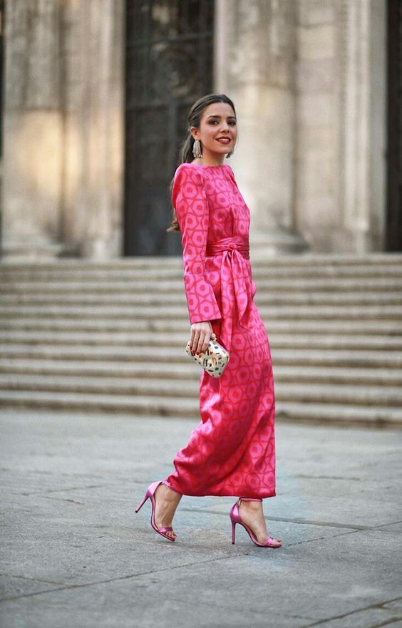 a shiny pink printed midi dress with a high neckline, long sleeves and accented shoulders, hot pink shoes and a printed clutch, statement earrings