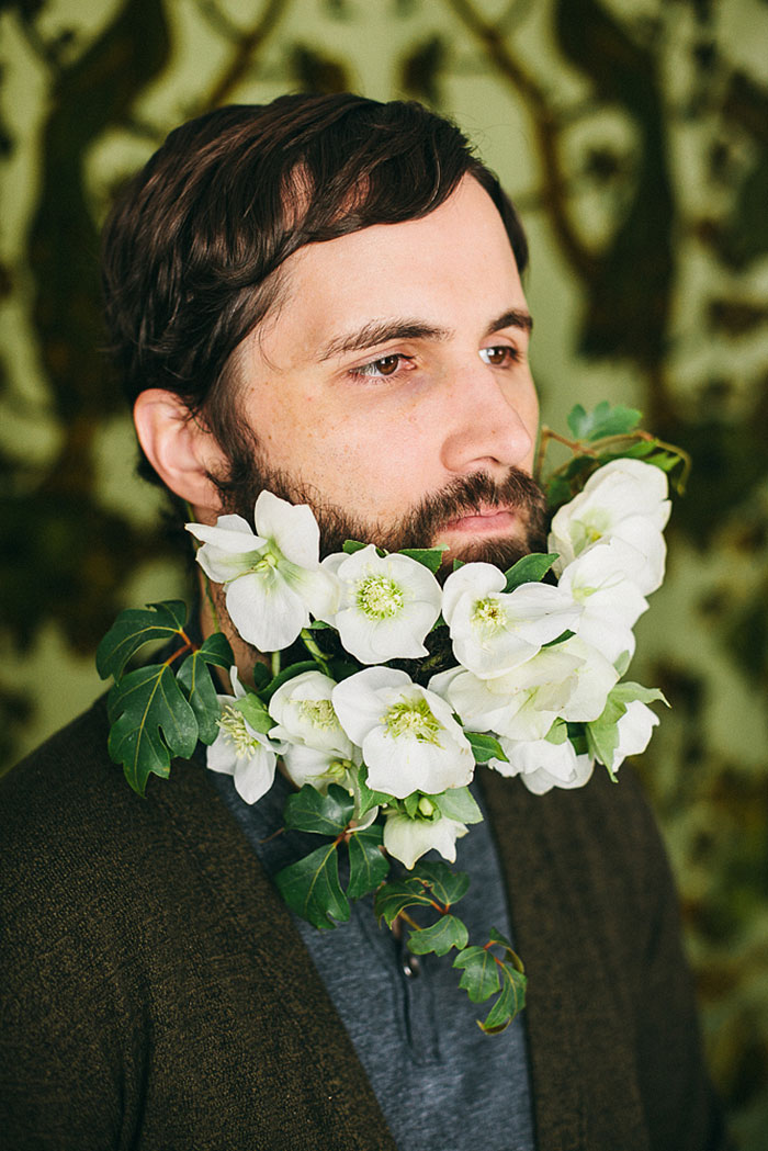 a beard fully decorated with white blooms and greenery is a fresh and bold idea for a spring groom