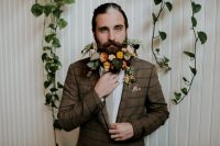 a vintage-looking groom with flowers in a beard