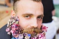 a groom rocking a romantic flower beard with pink, mauve, purple and lilac blooms looks dreamy and bold