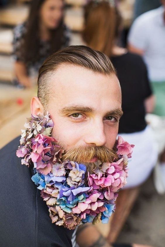 a groom rocking a romantic flower beard with pink, mauve, purple and lilac blooms looks dreamy and bold