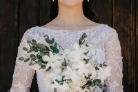 a refined bridal look with a lace wedding ballgown, statement earrings and a tiara plus clear and white framed eyeglasses