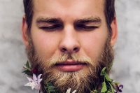 a spring groom’s look with a lilac and white striped shirt, with a floral beard with various wildflowers