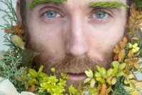 a super bold beard with greenery, with white, yellow, green blooms, some fall elaves and greenery eyebrows for a woodland look