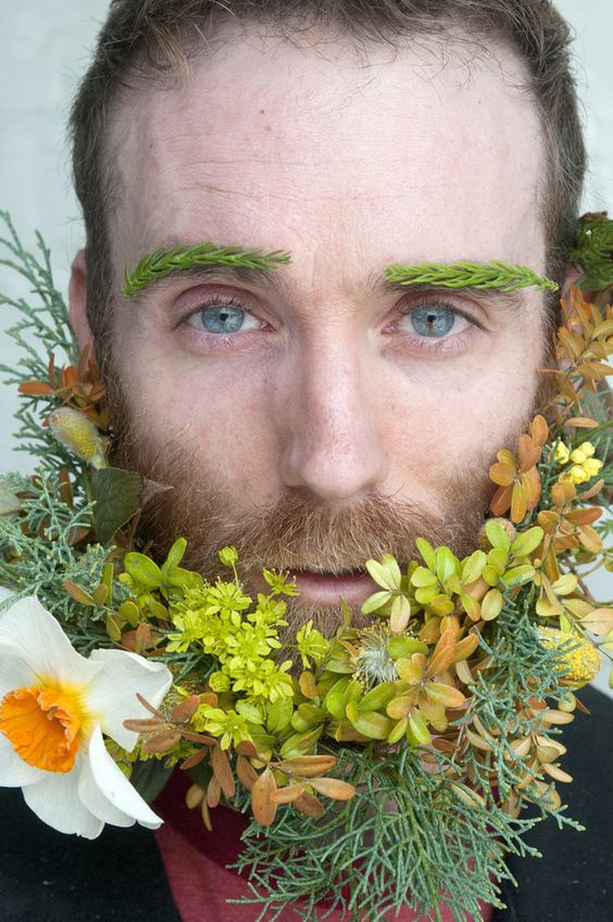 a super bold beard with greenery, with white, yellow, green blooms, some fall elaves and greenery eyebrows for a woodland look