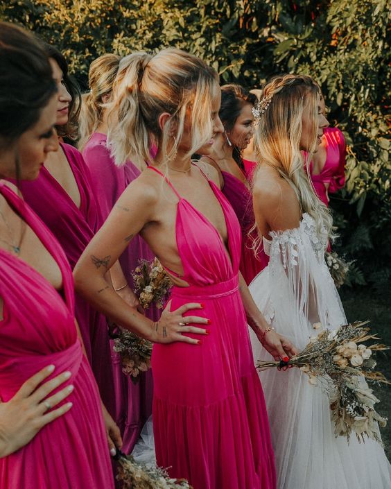 fantastic mismatching hot pink and fuchsia maxi bridesmaid dresses are ideal for rocking them at a tropical wedding