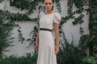 03 a modern plain A-line wedding dress with a high neckline, puff short sleeves, a back slit with buttons, a black sash and black earrings for a chic look