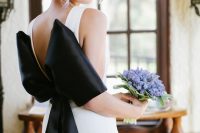 04 a modern plain wedding dress with a cutout back and an oversized black bow on the back for a statement black accent in the look