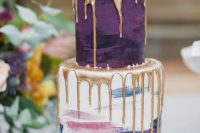 05 a catchy and chic wedding cake with a purple and a pastel brushstroke tier, with fresh berries, thistles and gold drip is a beautiful idea