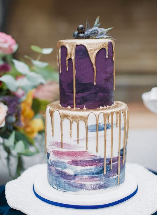 a catchy and chic wedding cake with a purple and a pastel brushstroke tier, with fresh berries, thistles and gold drip is a beautiful idea