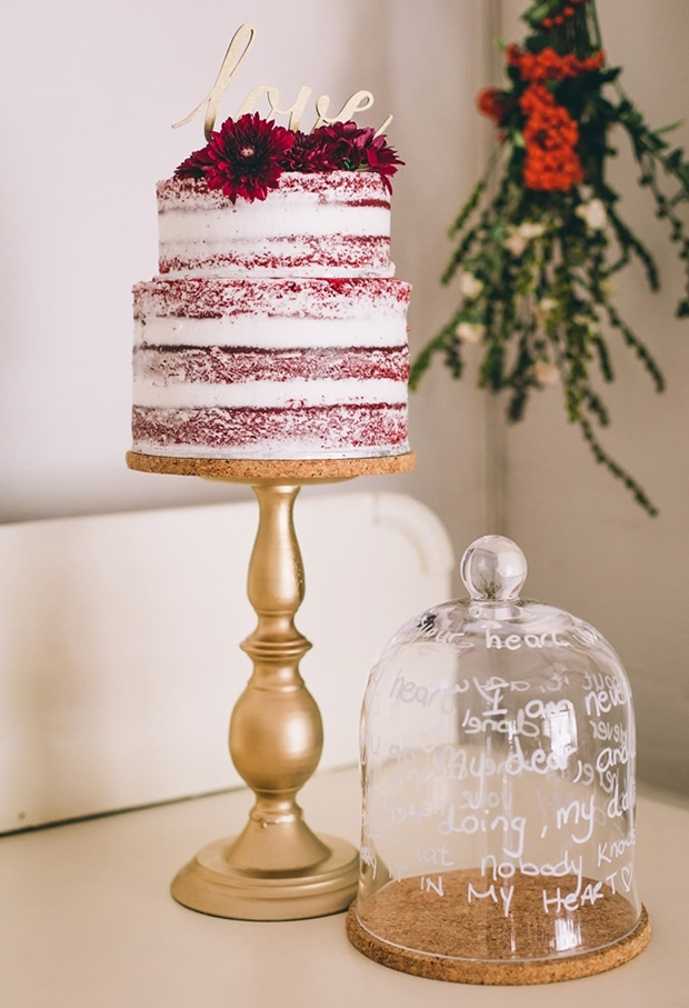 a chic red velvet semi-naked wedding cake topped with burgundy blooms and a gold calligraphy topper is a cool idea to rock in the fall