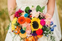 05 a colorful wedding bouquet with yellow, orange, pink and fuchsia blooms, greenery and colorful pompoms and ribbons is a bold touch